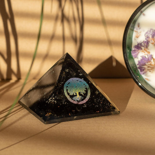 Orgonite pyramid with black tourmaline and tree of life on a table