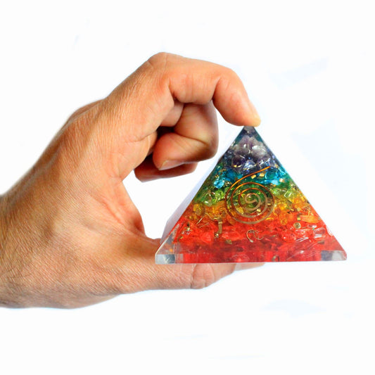 Hand holding Orgonite Pyramid with mixed gemstones and copper