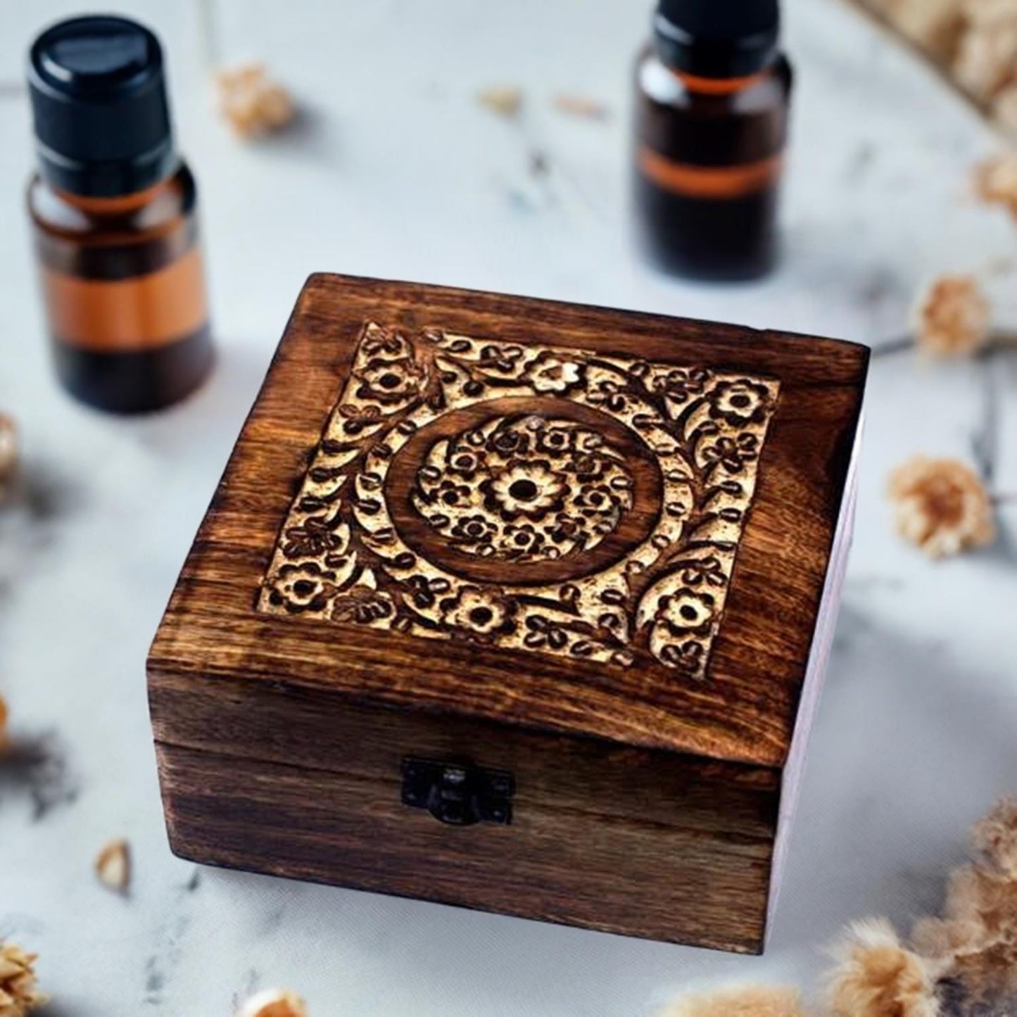 Hand carved mango wood essential oil storage box on marble table with oils