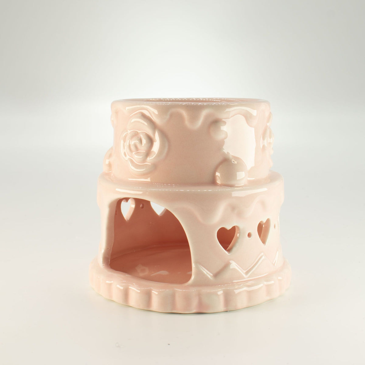 Pink ceramic oil burner with heart and rose designs on a white background