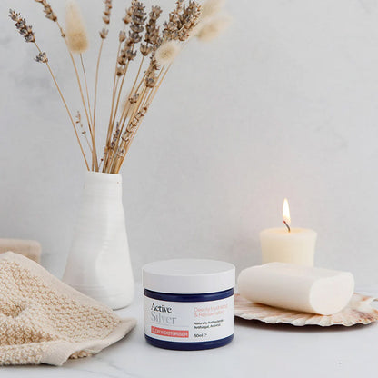 Active Silver Glow Moisturiser 50ml on table with candle