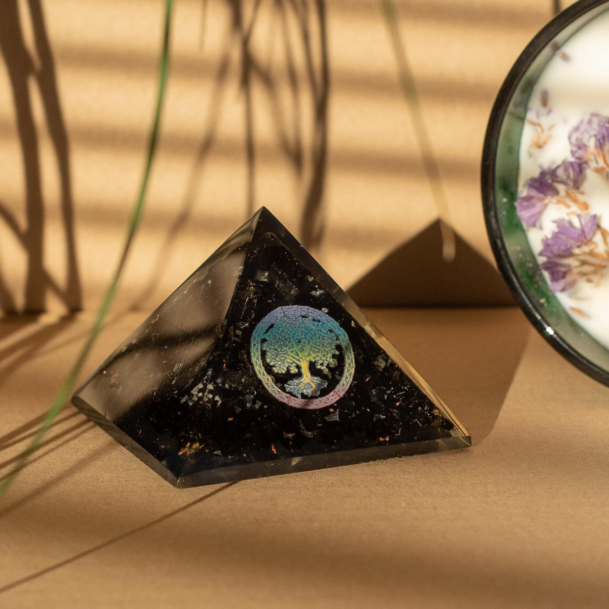 Orgonite pyramid with black tourmaline and tree of life on a table
