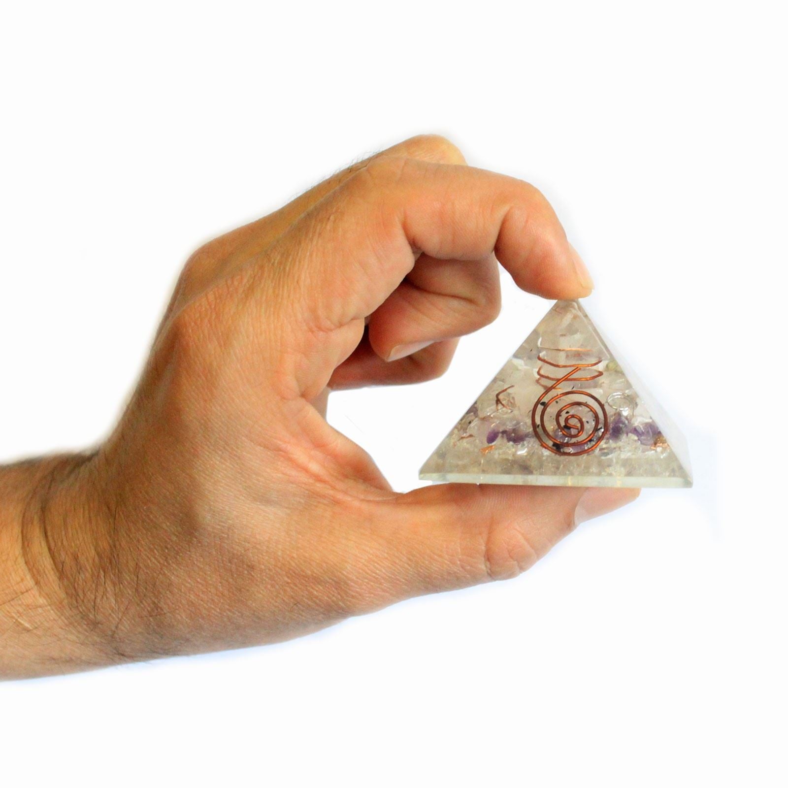 Hand holding orgonite pyramid with gemstones