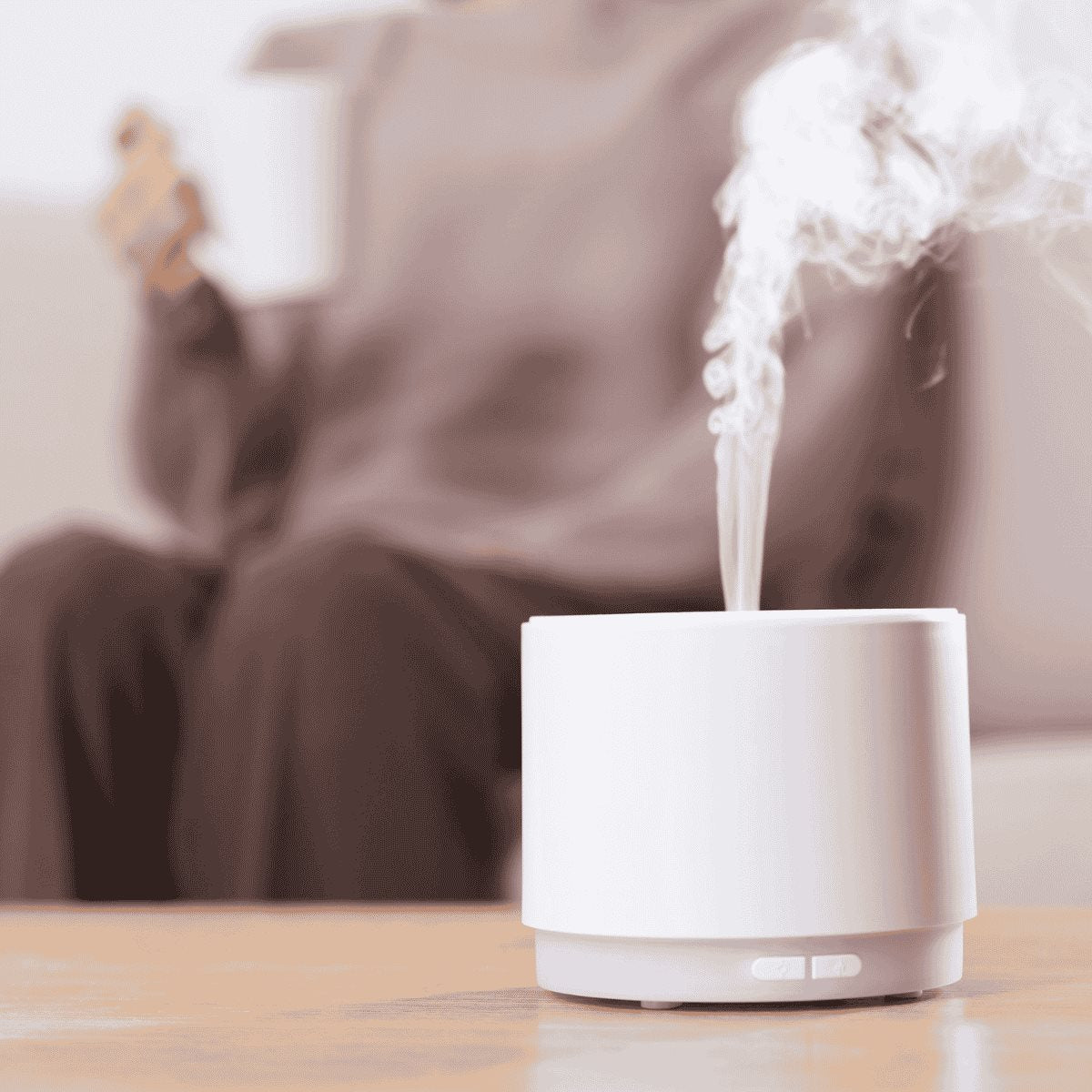 White diffuser emitting steam on a wooden surface 