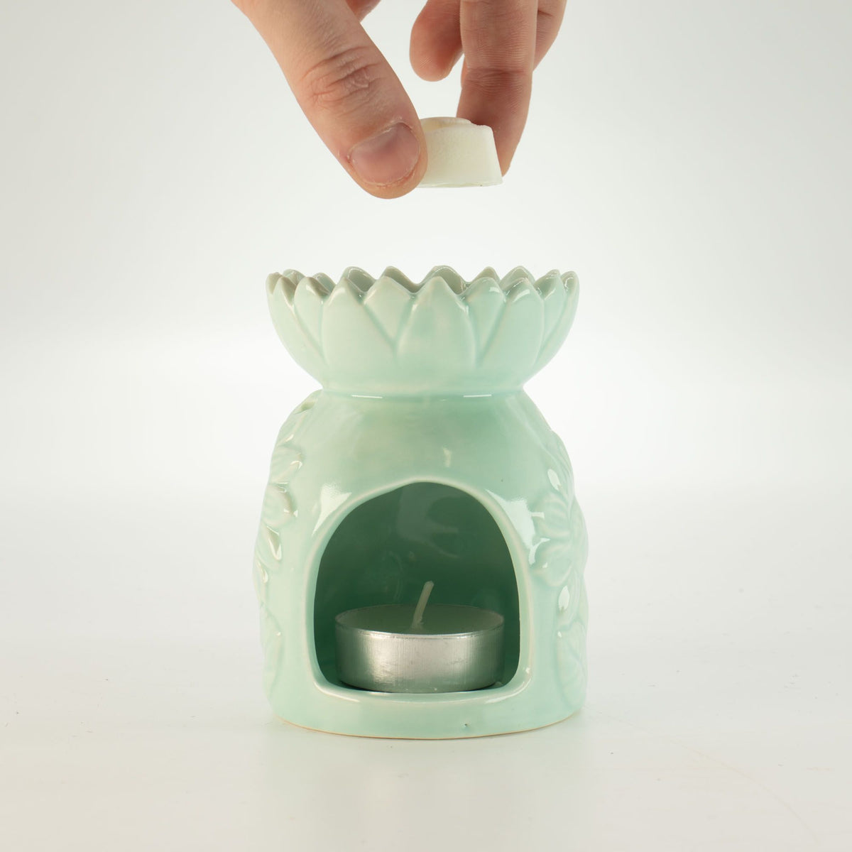Ceramic sunflower oil burner in pastel green with hand and wax melt