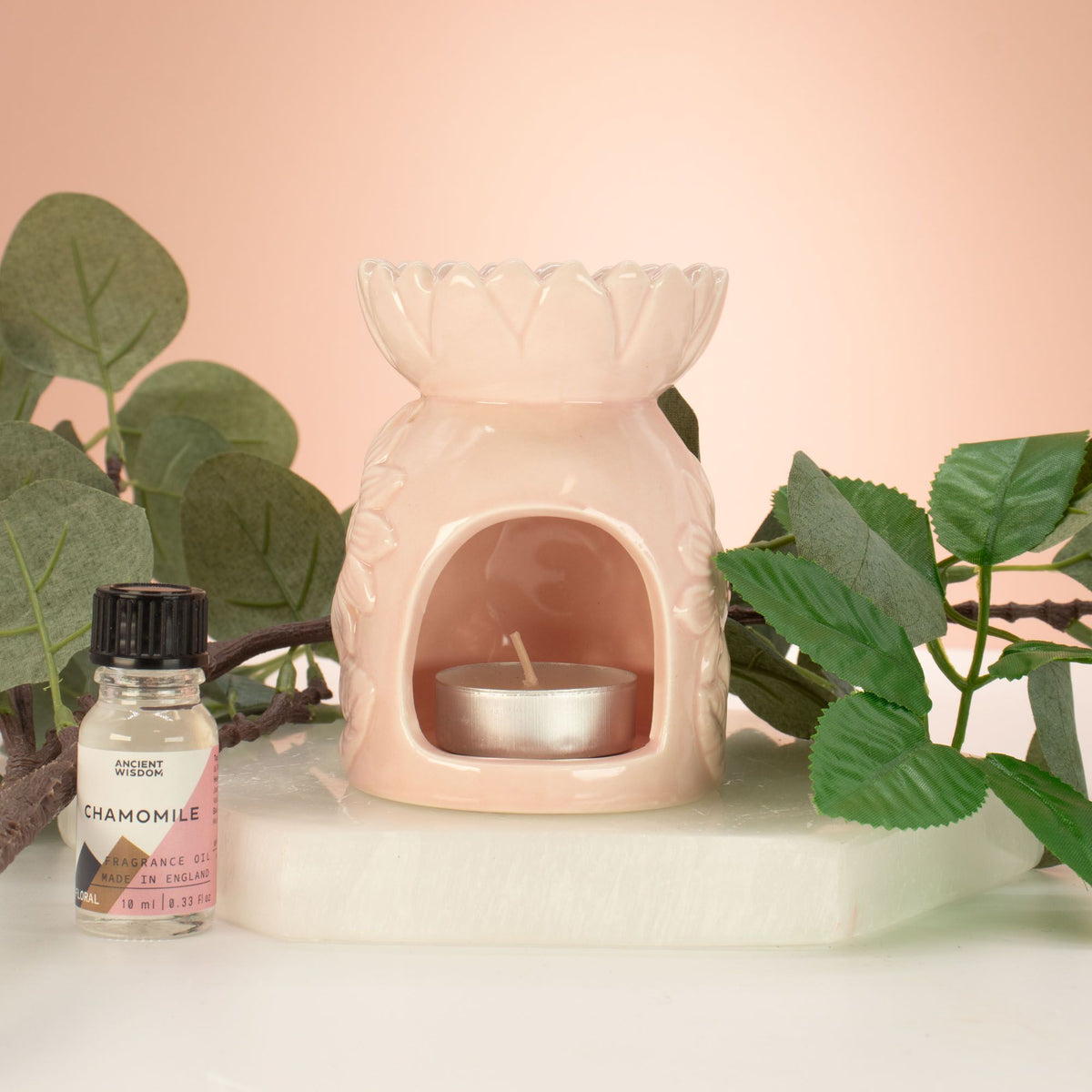 Ceramic sunflower oil burner on table with tea light