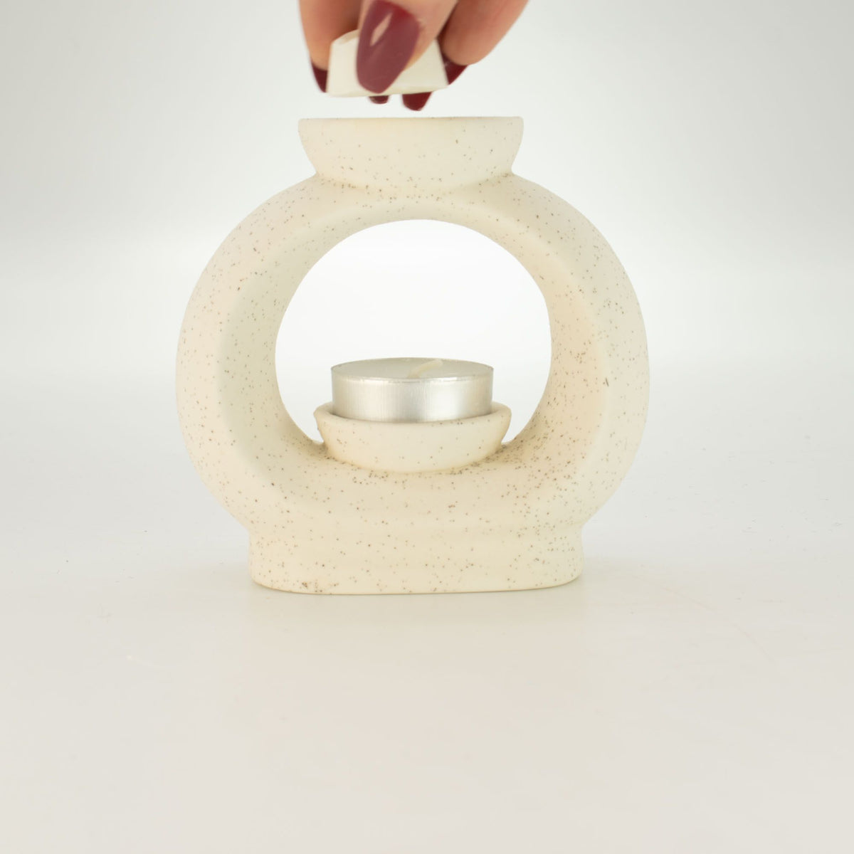 Ceramic Zen Oil Burner with tea light and hand putting in wax melt