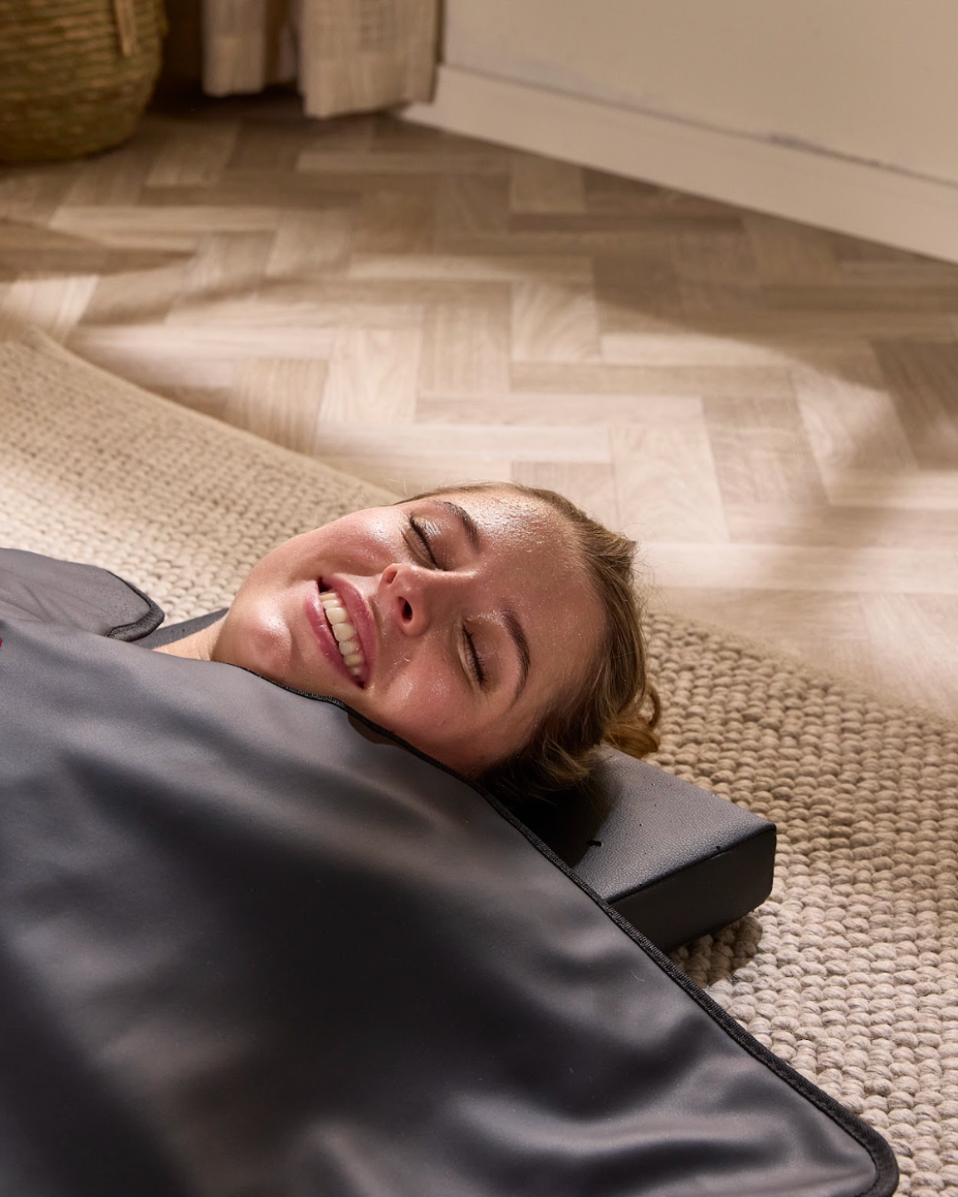 Woman lying in a flow sauna blanket with the air pillow