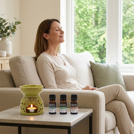 Forest Breeze lifestyle scene with a woman imagining a forest breeze beside the lit green burner and three oils