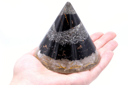 Black tourmaline, selenite and copper Orgonite cone in palm of hand